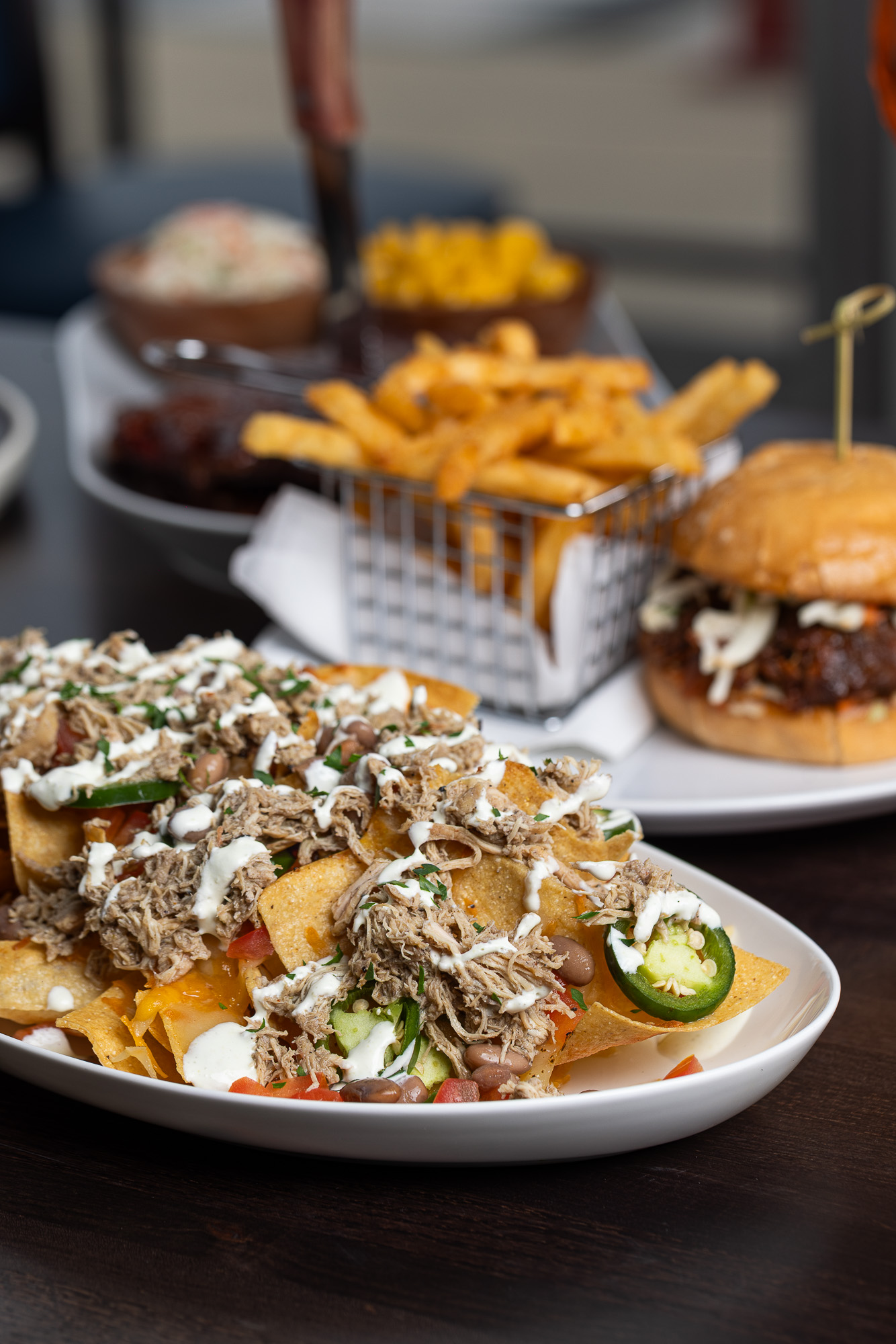 Loaded pulled pork nachos with sides and burger